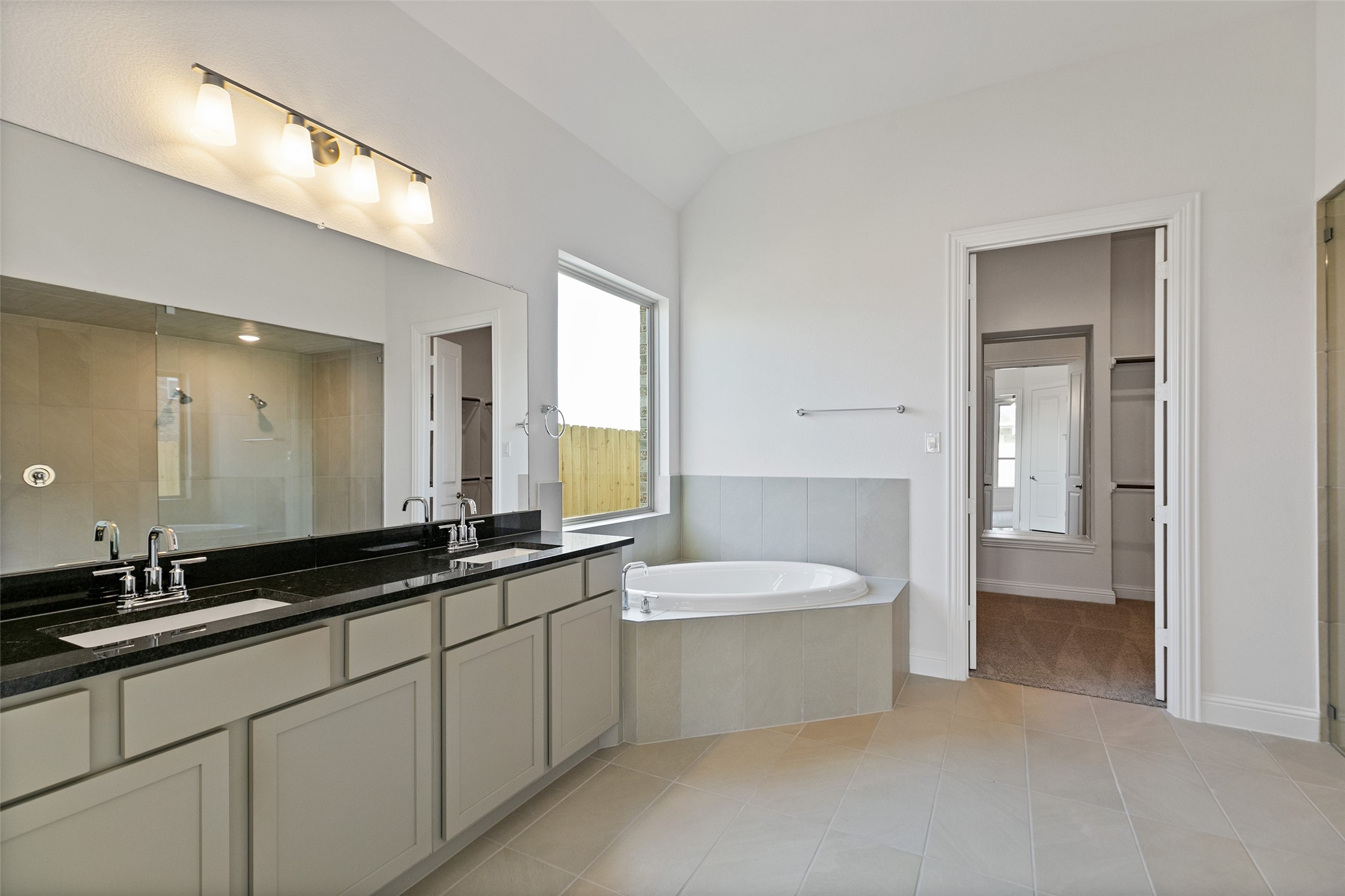 523 Blue River Trail Rosenberg, TX 77471 - Photo 27 of 34 a spacious bathroom with a double vanity sink a mirror and a bathtub