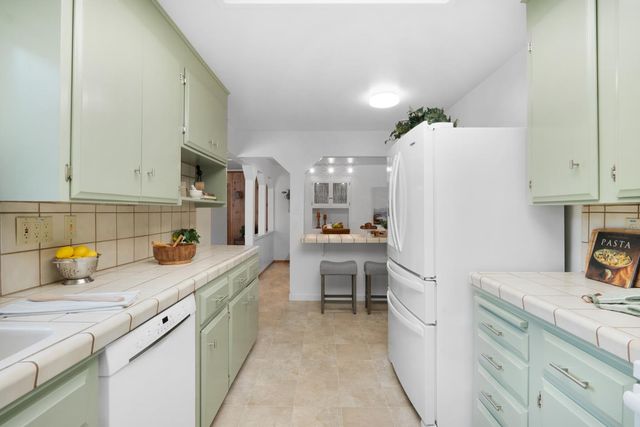 a kitchen with a sink refrigerator and cabinets
