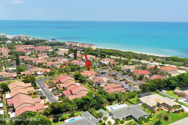 an aerial view of a city with ocean view in back