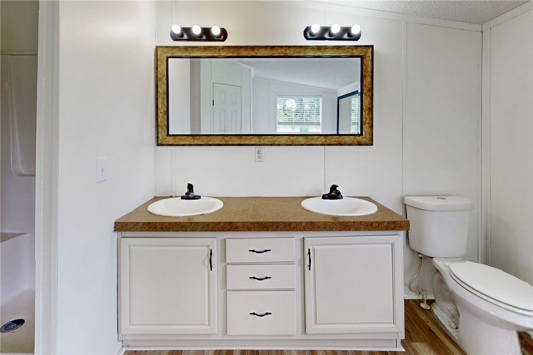 11459 Winstead Lane Calvert, TX 77837 - Photo 22 of 37 a bathroom with a toilet sink and mirror