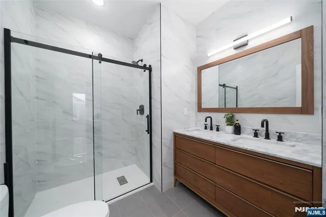 a bathroom with a shower sink vanity and mirror