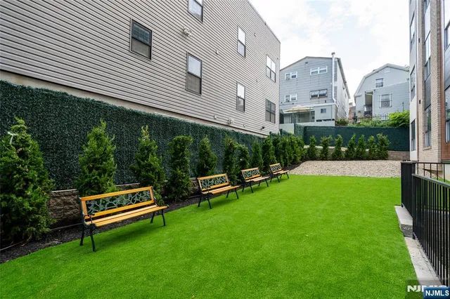 a view of a white house with a backyard and a patio