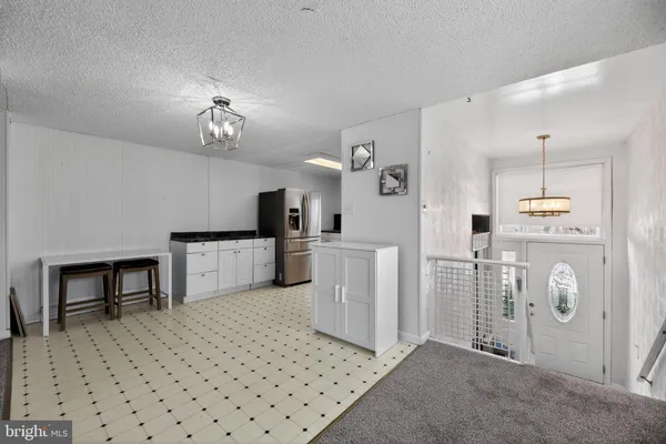a view of kitchen with furniture and refrigerator