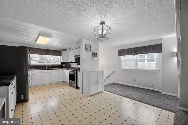 a kitchen with granite countertop a refrigerator and a stove top oven