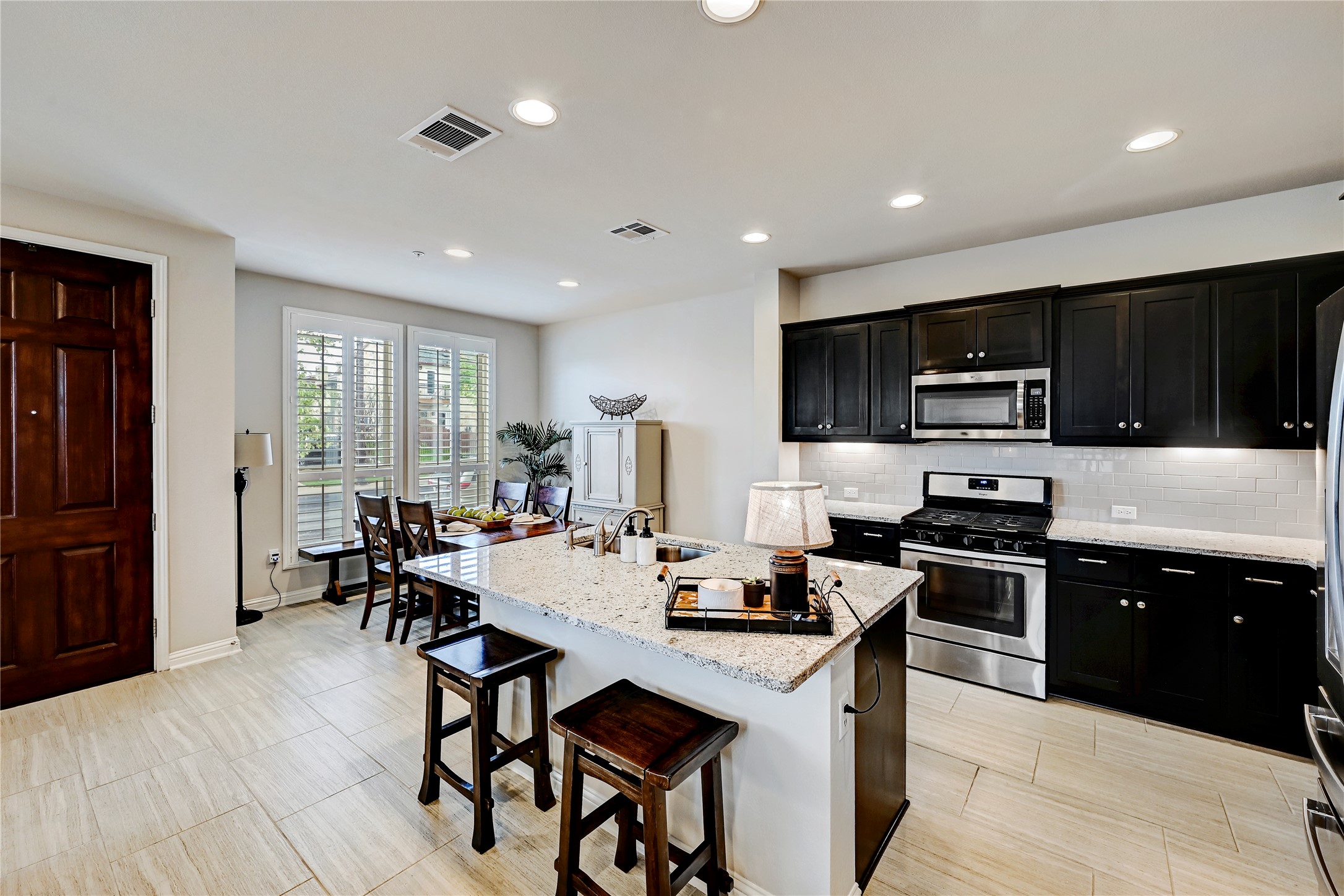 6814 East Riverside Drive, Unit 64 Austin, TX 78741 - Photo 6 of 17 An inviting open-concept kitchen features dark cabinetry, granite countertops, and modern appliances, creating a cohesive culinary space.