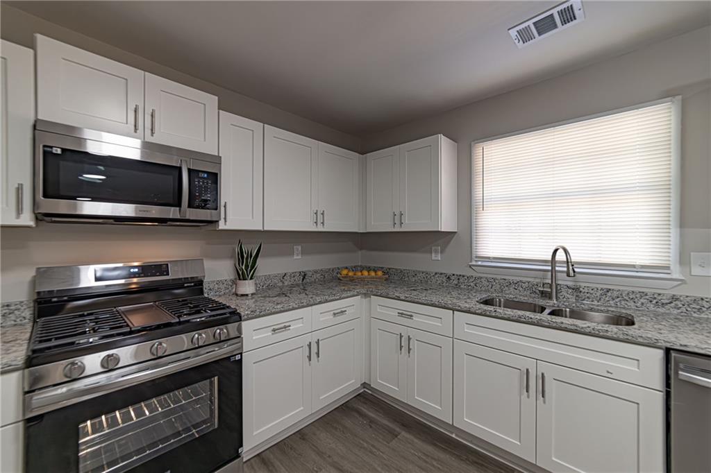 2362 Springrun Court Decatur, GA 30032 - Photo 28 of 83 a kitchen with stainless steel appliances granite countertop white cabinets granite counter tops and a window