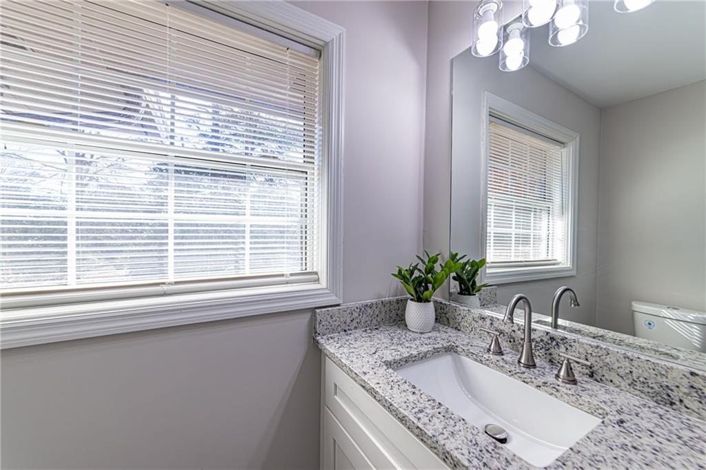 2362 Springrun Court Decatur, GA 30032 - Photo 54 of 83 a bathroom with a granite countertop sink a large mirror and a window