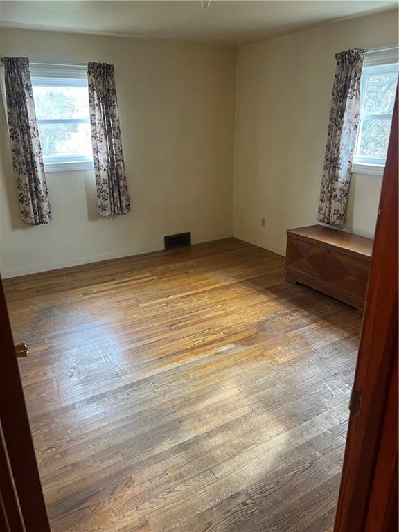 1277 Harrison City Export Road Jeannette, PA 15644 - Photo 8 of 17 a view of empty room with window and wooden floor