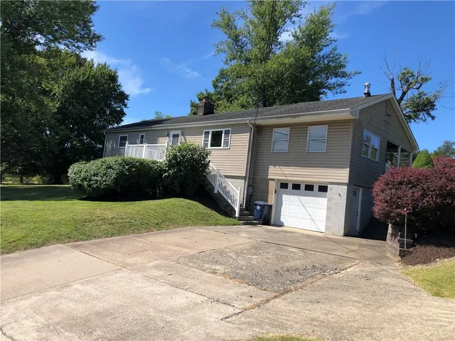 a view of a house with a yard and potted plants