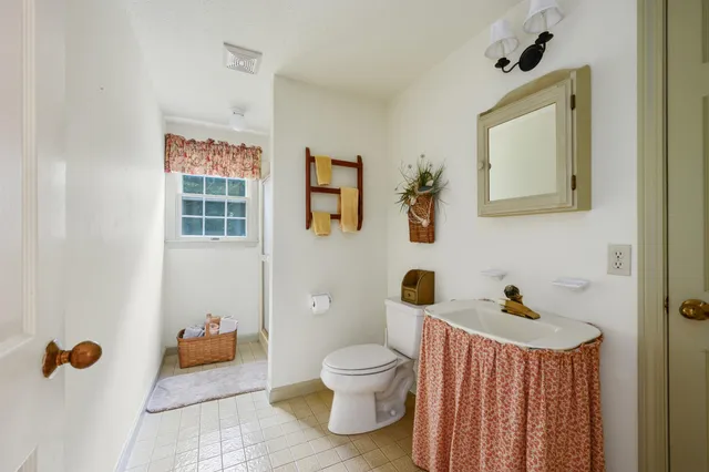 a bathroom with a toilet sink a mirror and shower