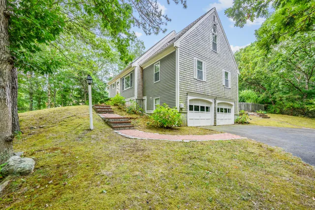 a front view of house with yard and trees around