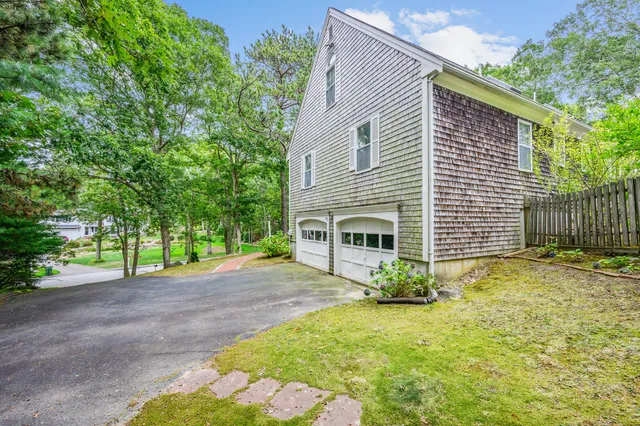 a view of a house with backyard and a tree