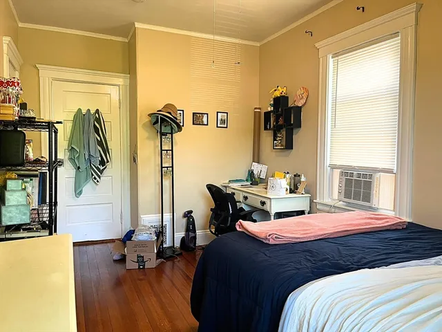 a bedroom with a bed and wooden floor