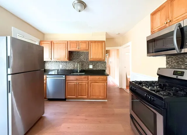 a kitchen with stainless steel appliances granite countertop a refrigerator stove and microwave