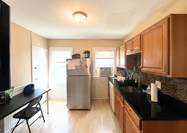 a kitchen with a refrigerator a stove a sink a counter space and dining table