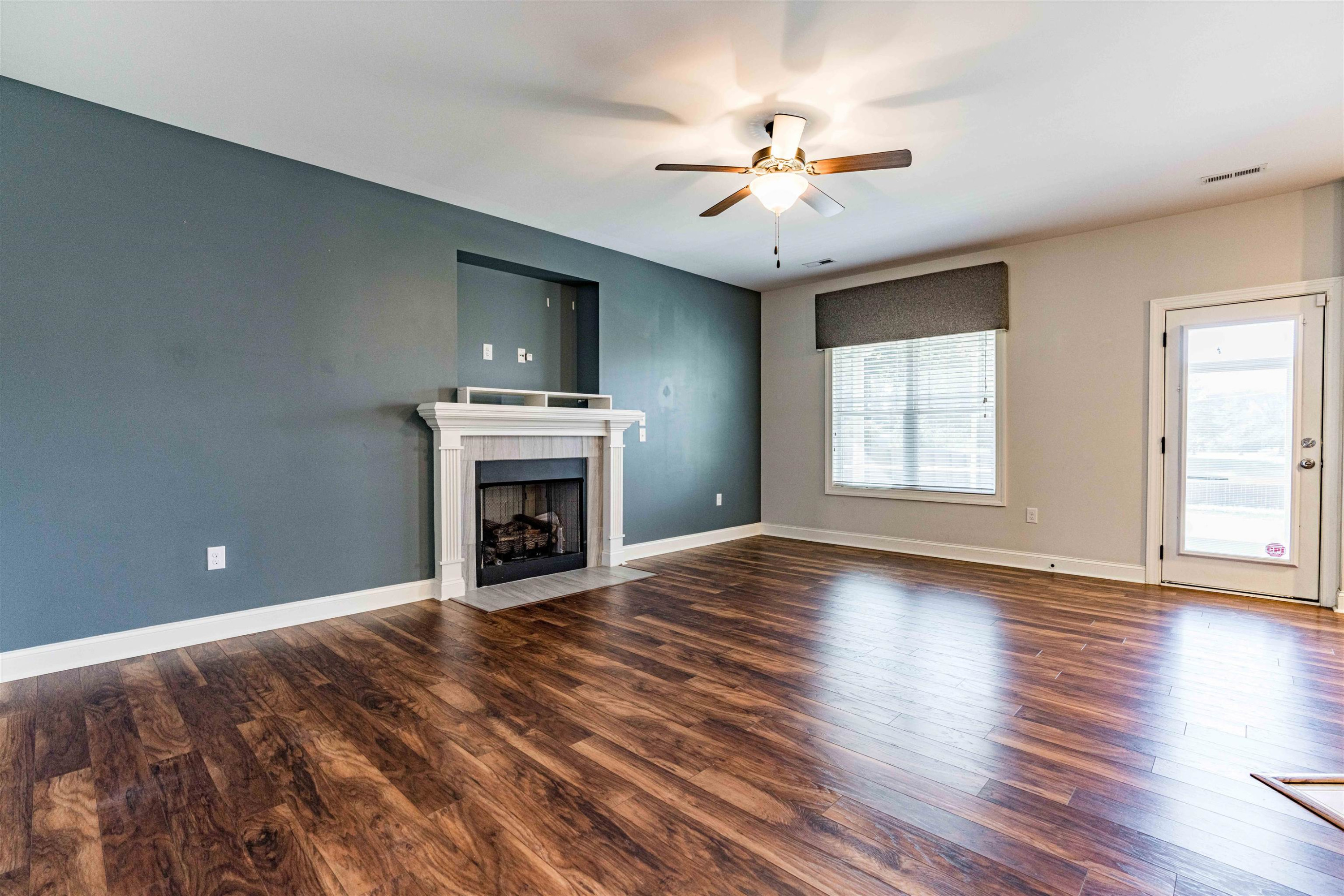 118 Colson Drive Garner, NC 27529 - Photo 13 of 47 a view of an empty room with wooden floor fireplace and a window
