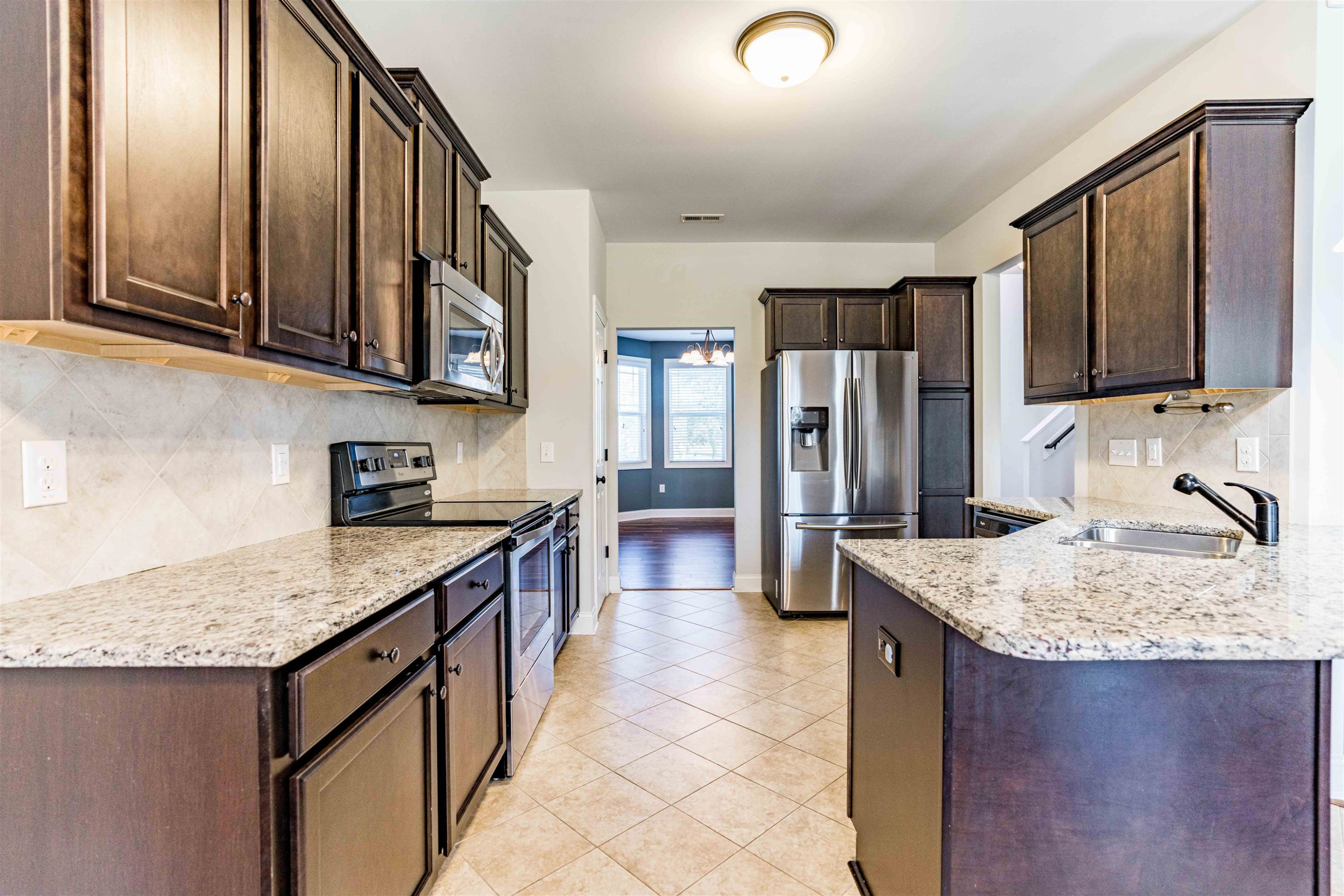 118 Colson Drive Garner, NC 27529 - Photo 16 of 47 a kitchen with stainless steel appliances granite countertop a sink stove refrigerator and cabinets