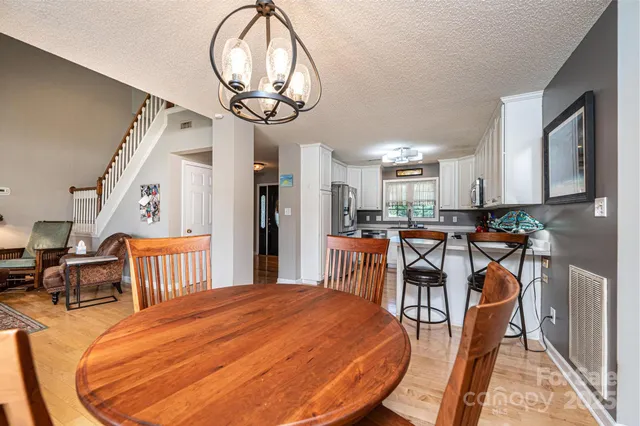 a view of a dining room with furniture a chandelier and wooden floor