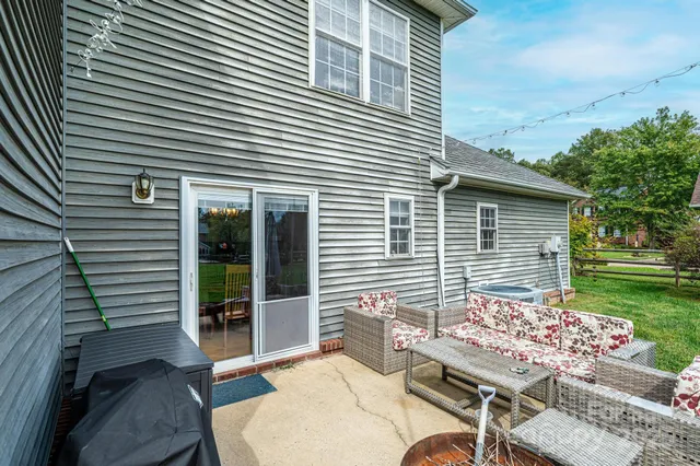 a view of a patio with a table and chairs next to a yard