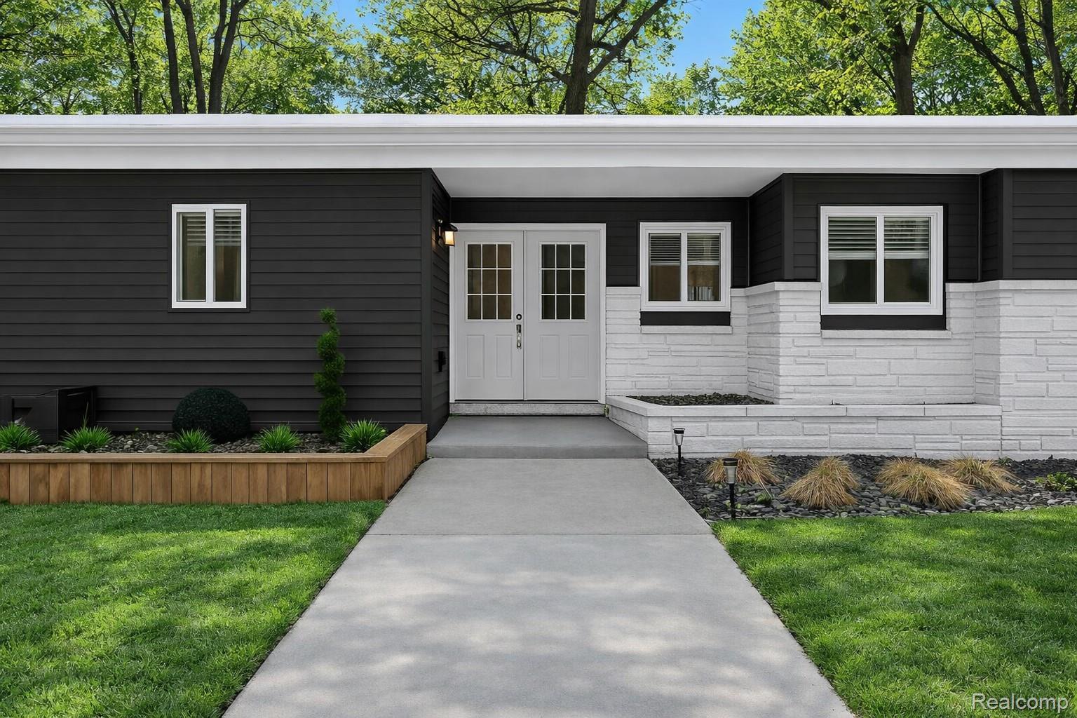 View of exterior entry with french doors and a lawn