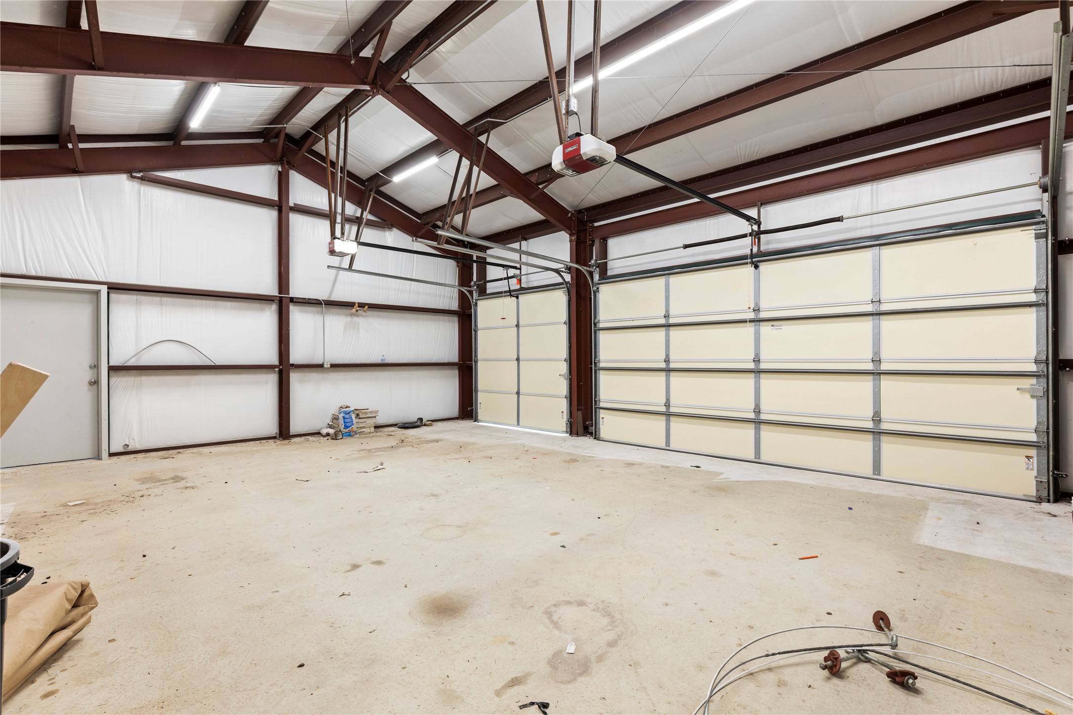 1293 Pioneer Road Seguin, TX 78155 - Photo 26 of 40 A spacious garage with concrete flooring, illuminated by modern overhead lighting.