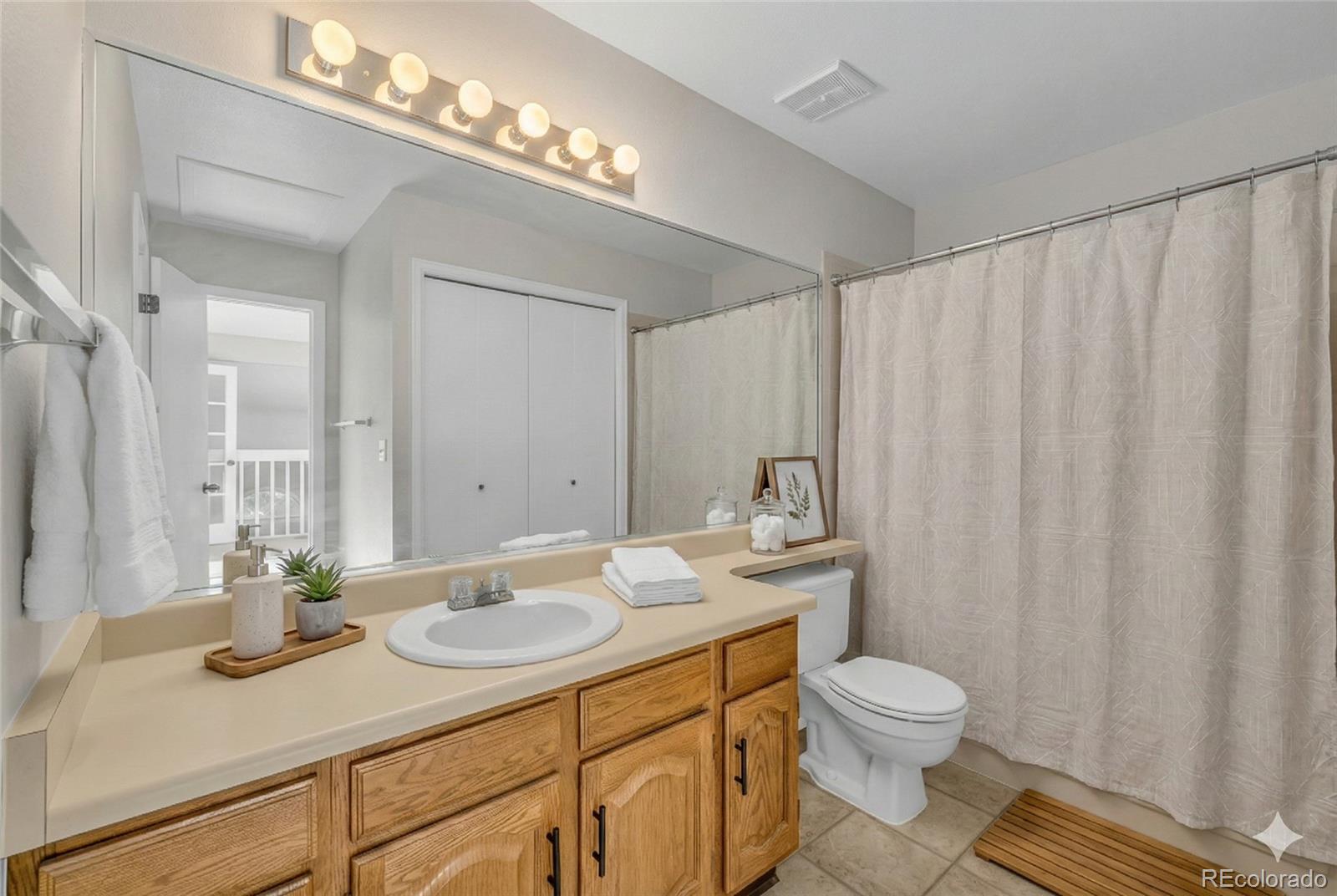 9390 Yale Lane Highlands Ranch, CO 80130 - Photo 11 of 50 a bathroom with a granite countertop sink a toilet and a mirror