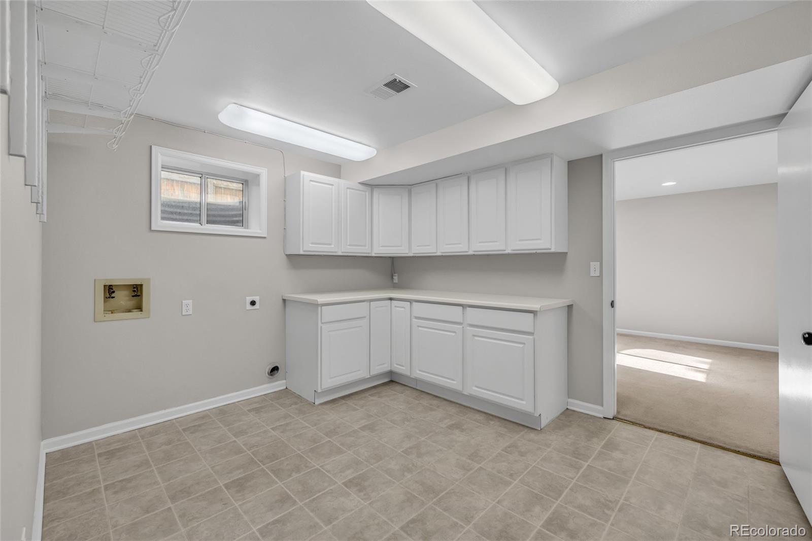 9390 Yale Lane Highlands Ranch, CO 80130 - Photo 38 of 50 a kitchen with white cabinets and white appliances