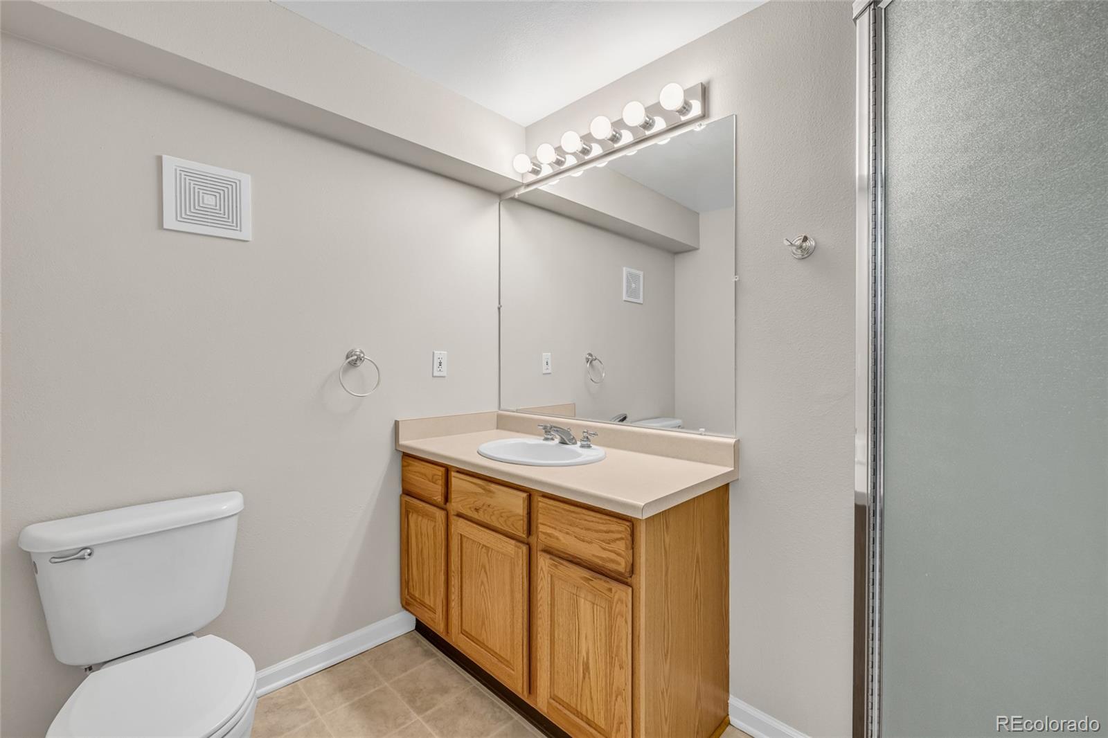 9390 Yale Lane Highlands Ranch, CO 80130 - Photo 39 of 50 a bathroom with a toilet sink vanity and mirror