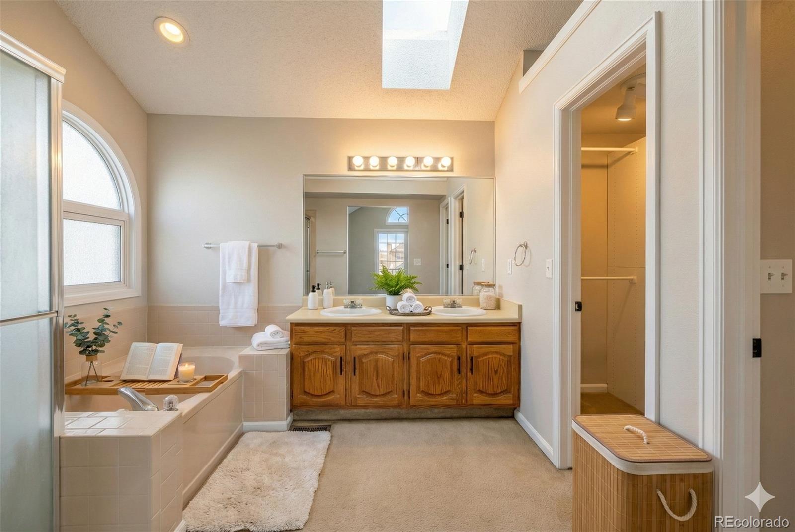 9390 Yale Lane Highlands Ranch, CO 80130 - Photo 9 of 50 a spacious bathroom with a granite countertop sink a mirror and a bathtub