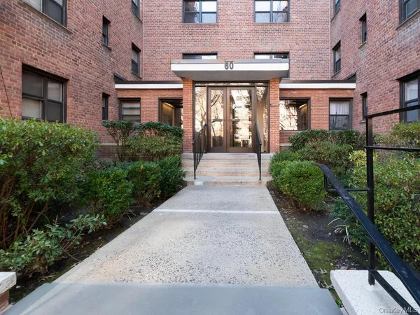 front view of a brick house with a yard