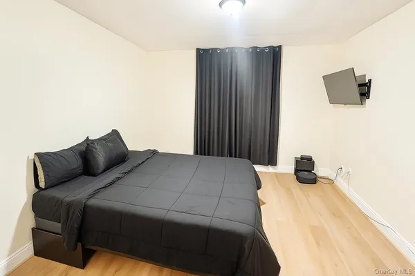 a bedroom with a bed and a flat screen tv