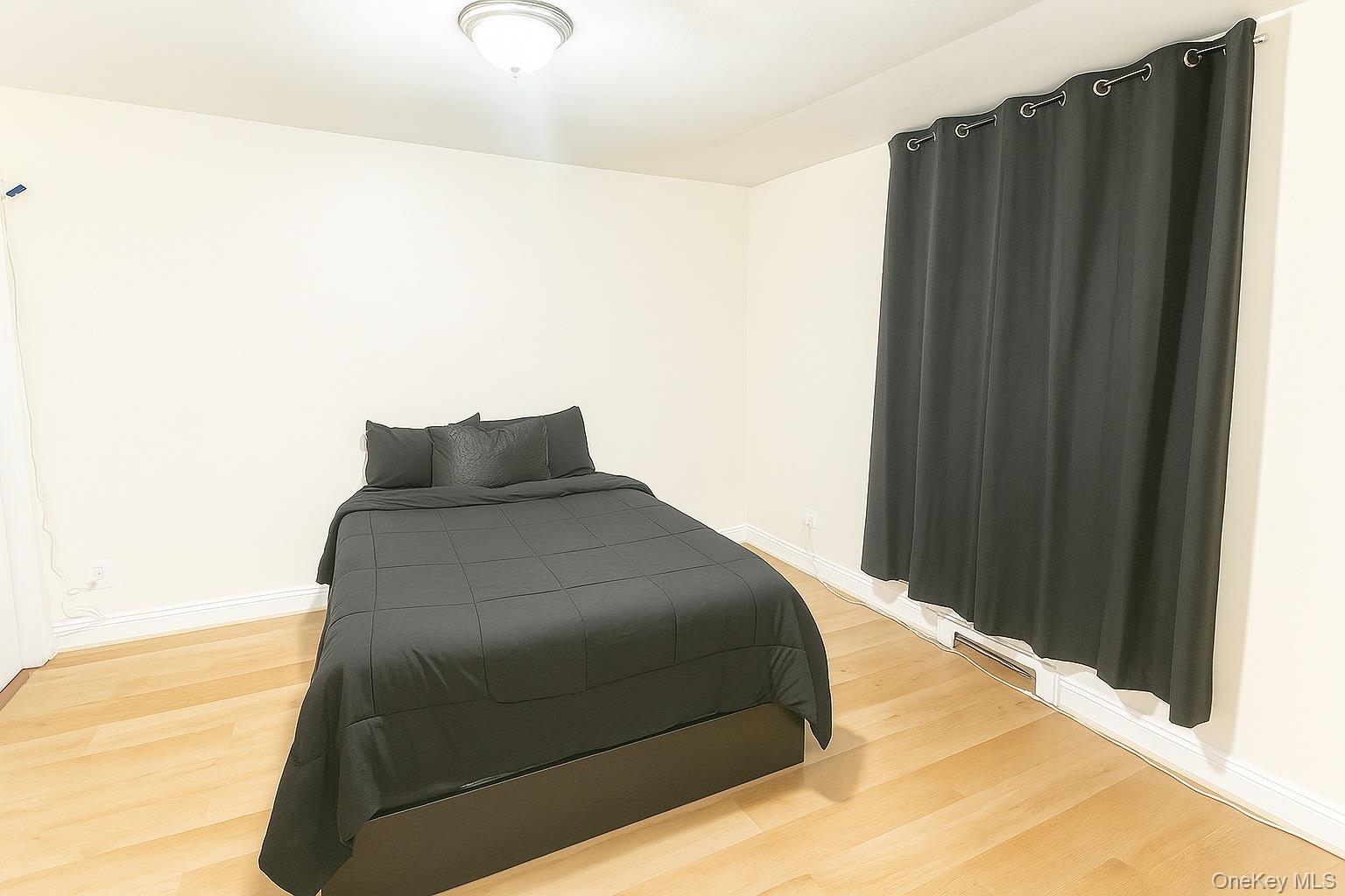 60 White Oak Street, Unit 2H New Rochelle, NY 10801 - Photo 4 of 15 a bedroom with a bed and a cabinets