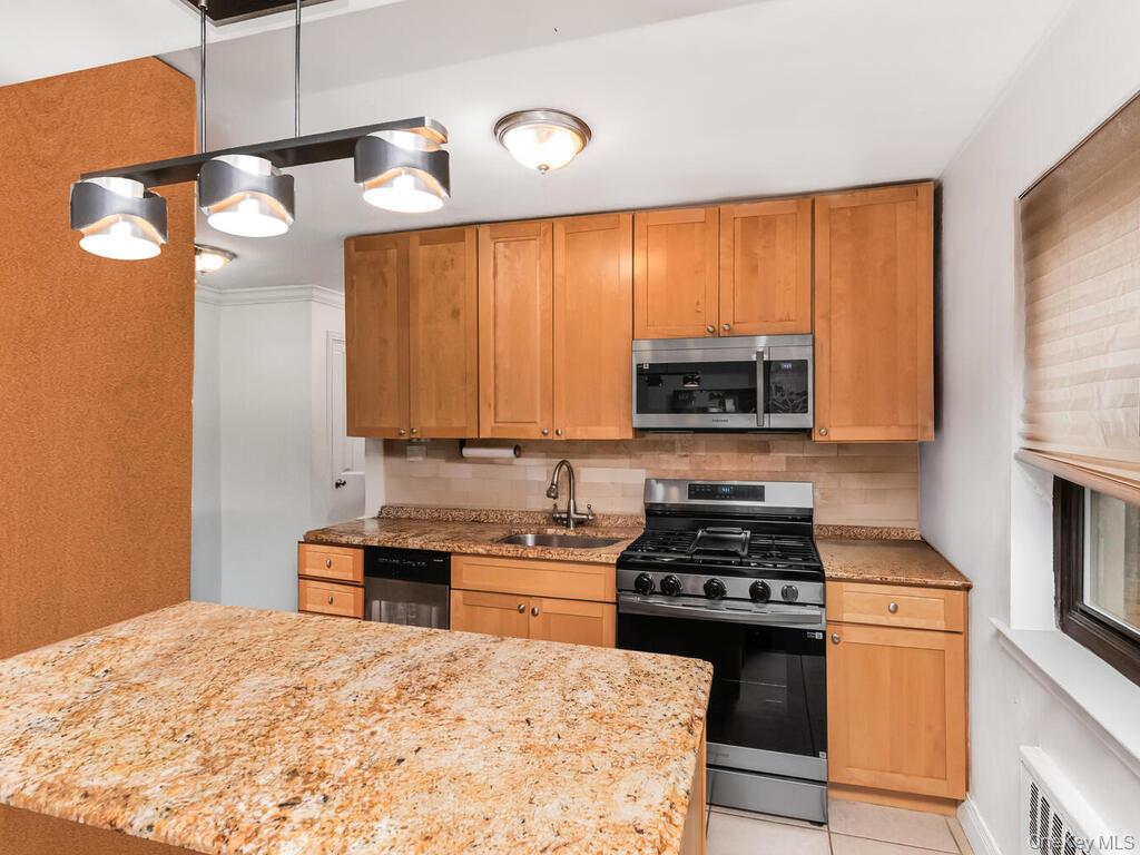 60 White Oak Street, Unit 2H New Rochelle, NY 10801 - Photo 8 of 15 a kitchen with a stove a sink and a microwave