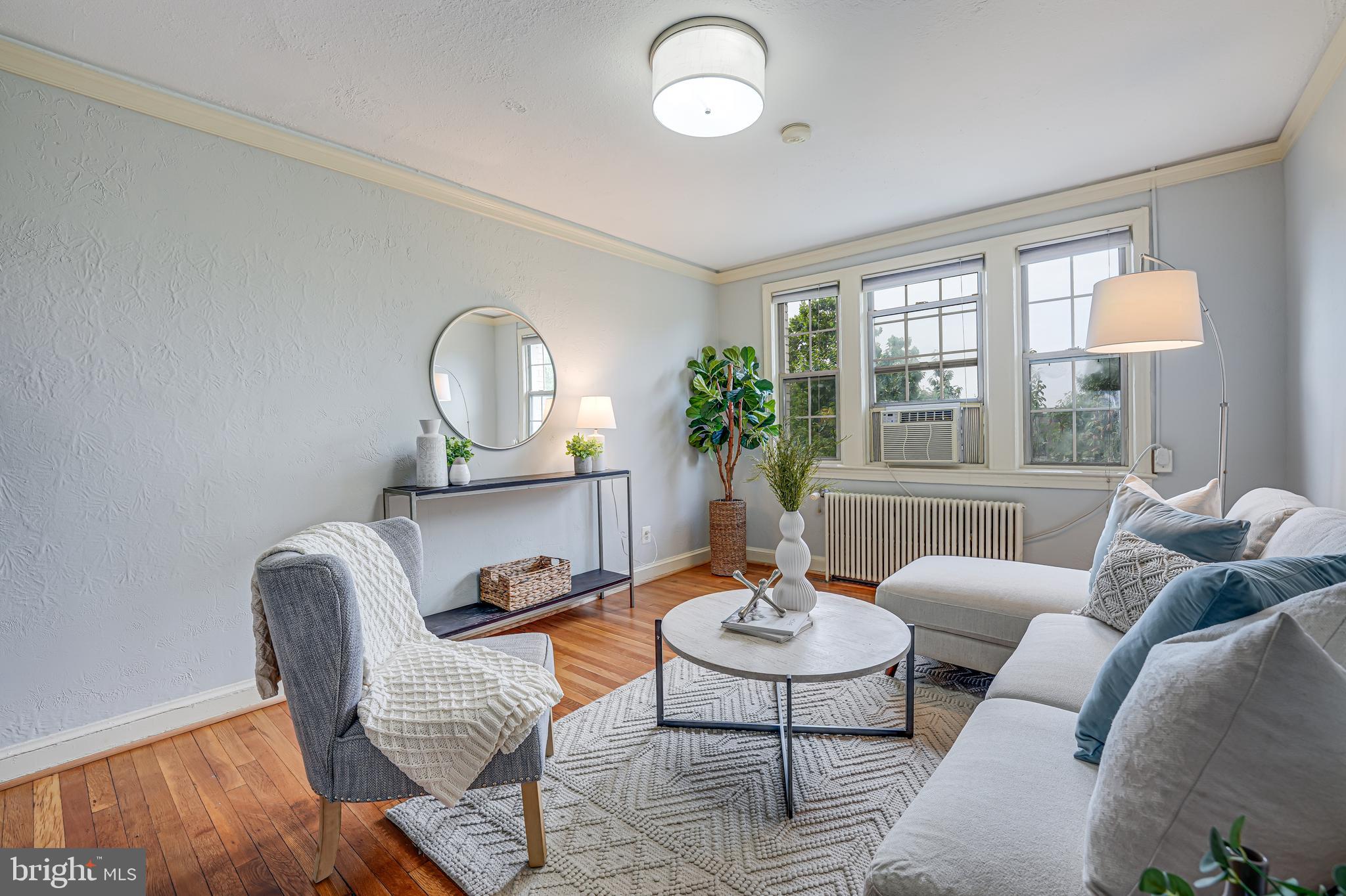 1441 Euclid Street Northwest, Unit 301 Washington, DC 20009 - Photo 11 of 18 a living room with furniture a table and a large window