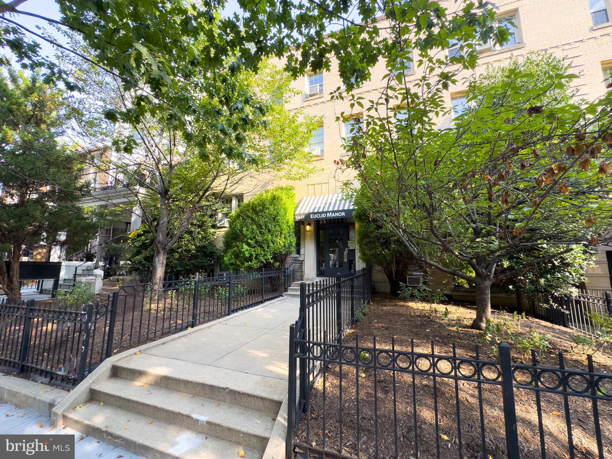 1441 Euclid Street Northwest, Unit 301 Washington, DC 20009 - Photo 3 of 18 a view of a patio with table and chairs and potted plants with large trees