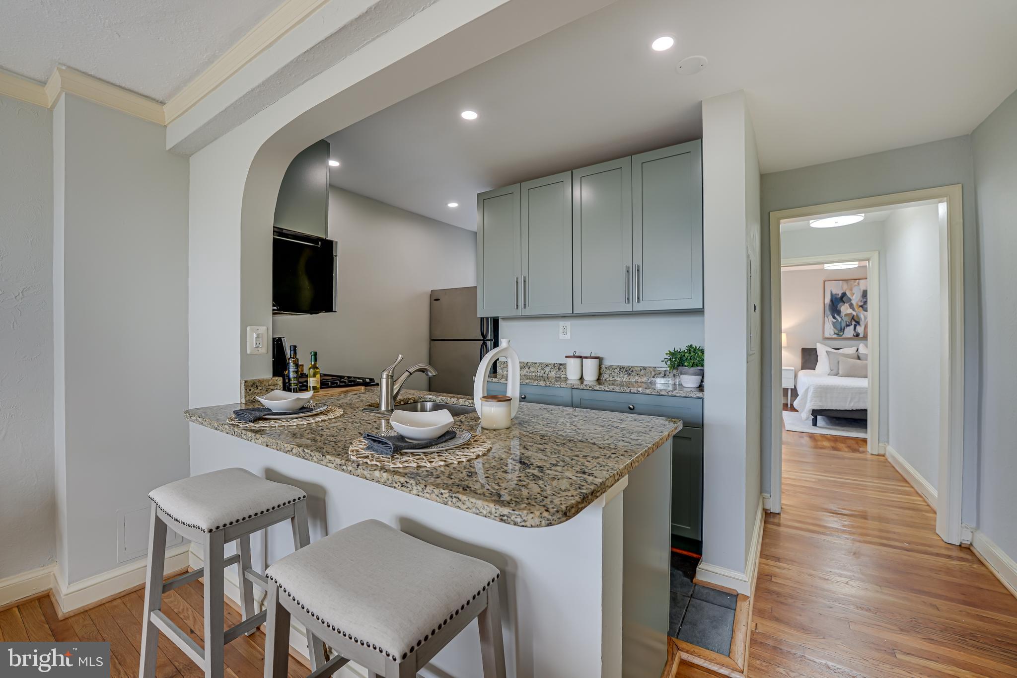 1441 Euclid Street Northwest, Unit 301 Washington, DC 20009 - Photo 4 of 18 a kitchen with a sink a table and chairs in it