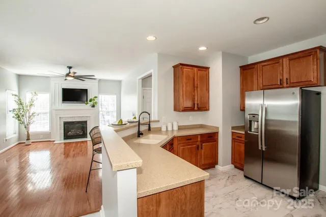 a kitchen with stainless steel appliances granite countertop a refrigerator a stove and a sink with cabinets