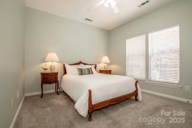 a spacious bedroom with a bed and a lamp