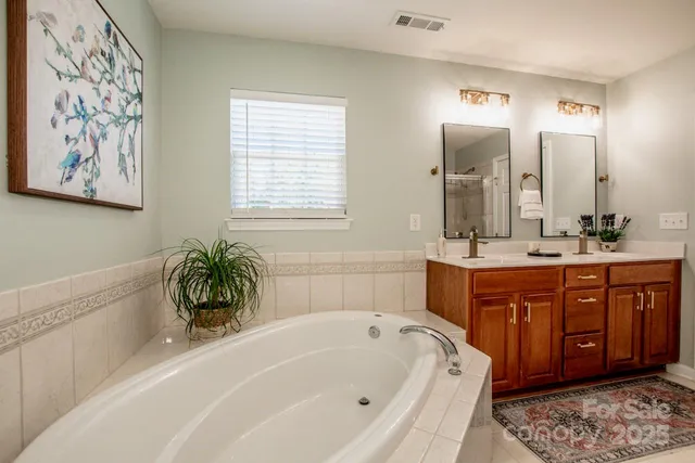 a bathroom with a tub sink and mirror