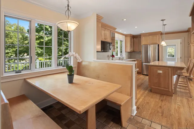 a kitchen with a table chairs refrigerator and wooden floor
