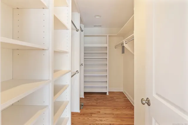 a view of walk in closet with empty racks
