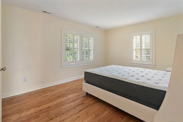 a bed sitting in a bedroom next to a window