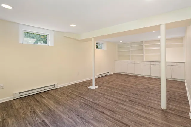 an empty room with wooden floor and white walls