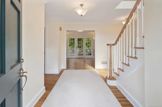 a view of a hallway with wooden floor and staircase