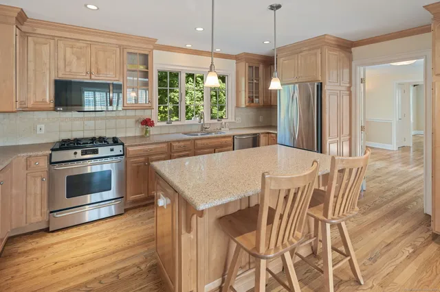 a kitchen with stainless steel appliances a stove a refrigerator sink and microwave