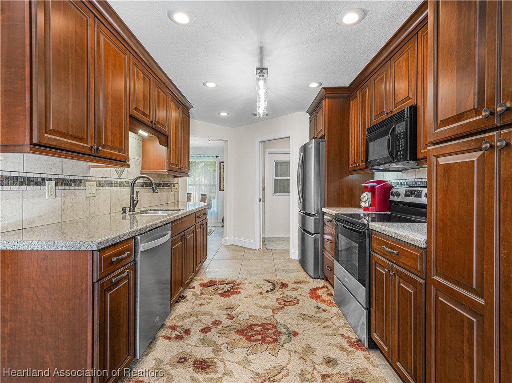 3206 Divot Road Sebring, FL 33872 - Photo 11 of 40 View from kitchen sliding glass door toward dining area and laundry room to garage.