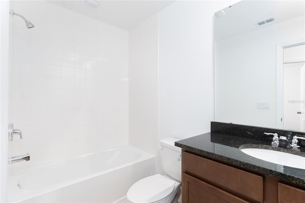 987 Spring Palms Loop Orlando, FL 32828 - Photo 17 of 23 a bathroom with a granite countertop sink toilet and bathtub
