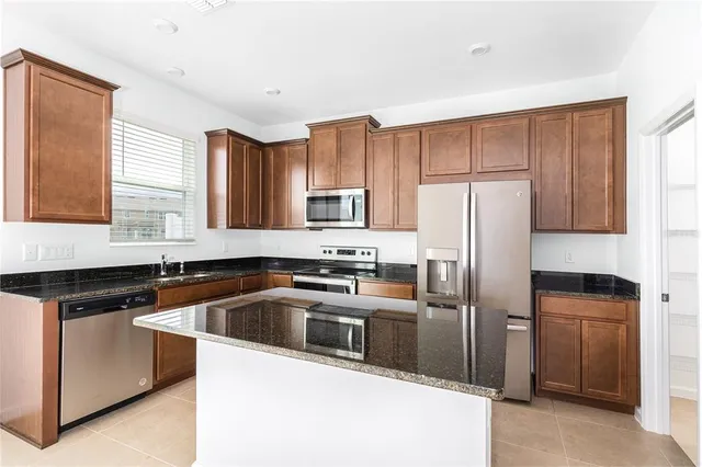 a kitchen with a refrigerator sink and cabinets