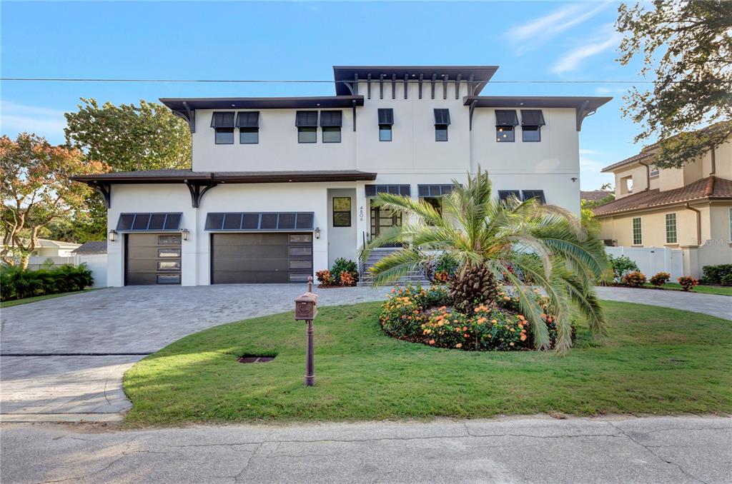 a front view of a house with a garden and plants