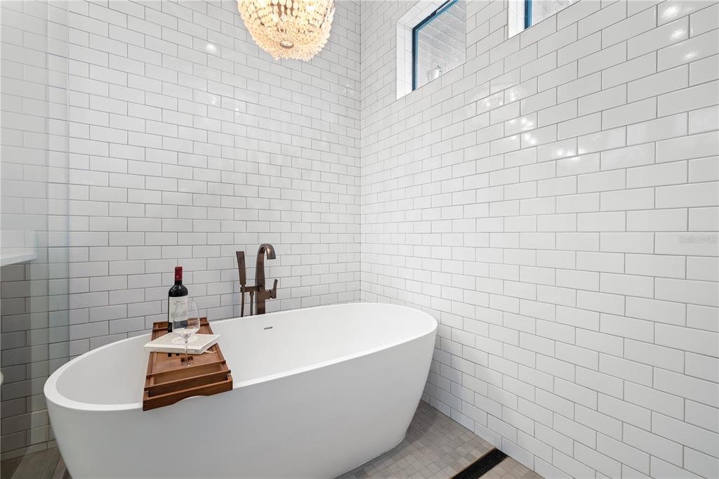 4806 West San Rafael Street Tampa, FL 33629 - Photo 25 of 60 a bathroom with a white tub a sink and a mirror